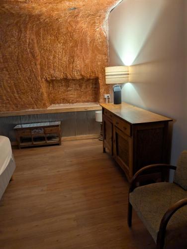 a room with a desk and a bed and a chair at Desert Gum Grund st in Coober Pedy