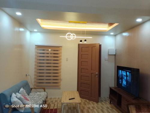 ジェネラル・サントスにあるHouse of Gabrielleの青いソファとテレビのあるリビングルーム