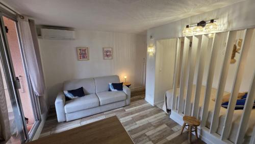 a living room with a couch and a bed at Studio Le miroir à Saint Aygulf in Saint-Aygulf