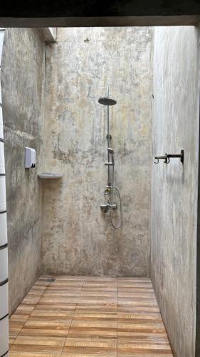 a bathroom with a shower in a concrete wall at KohMakHomeHug Resort in Ko Mak
