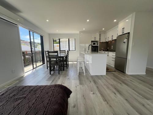 Una cocina y una sala de estar con mesa y sillas. en Modern Family Home in Tawa - Wellington, en Wellington