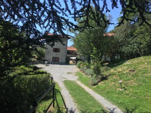 a house on a hill with a dirt road at Cascina Cologna in Galbiate