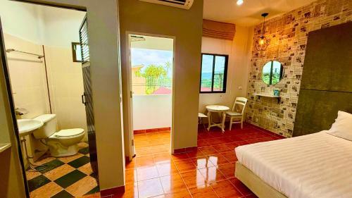 a bedroom with a bed and a bathroom with a sink at Cozy Bay Rawai in Phuket Town