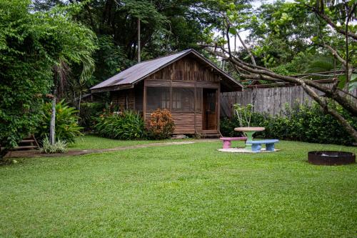 a small wooden cabin with a bench in a yard at Hotel Cabañas La Teca in Liberia