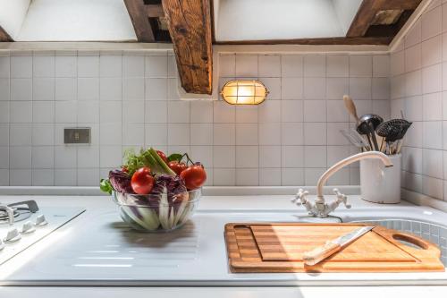 a kitchen counter with a bowl of vegetables on a cutting board at The Venetian Penthouse in Venice