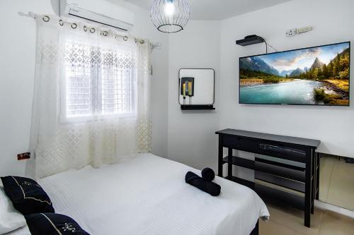 a bedroom with two beds and a tv on the wall at וילת האגם - וילה מהממת בטבריה עם בריכה פרטית in Tiberias