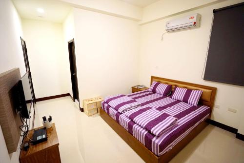 a bedroom with a bed and a tv in it at Love Door 168 in Huxi