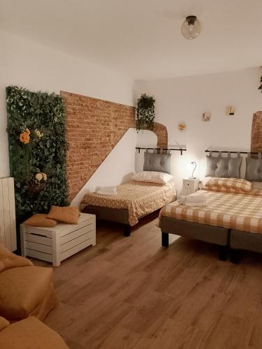 a bedroom with two beds and a brick wall at Guest House Vecchia Tranvia in Pisa
