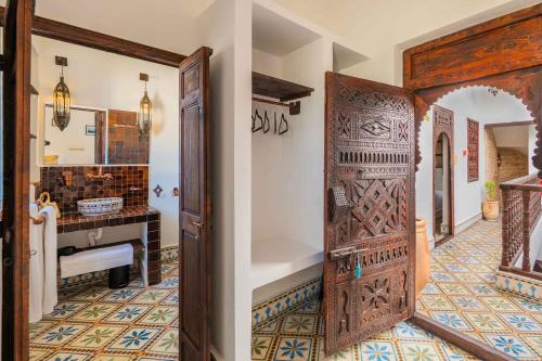 an entrance to a bathroom with a wooden door at Riad Dar Irdide in Essaouira