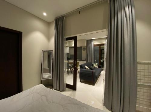 a bedroom with a bed and a couch and a mirror at Hawana Salalah Tourism in Ma‘mūrah