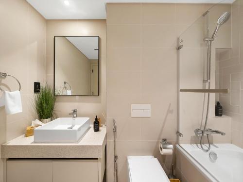 a bathroom with a sink and a mirror and a tub at Chic 1 Bedroom on Private Beach in Dubai Harbour in Dubai