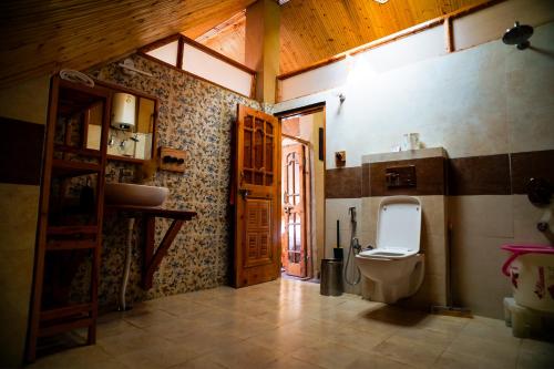 a bathroom with a toilet and a sink at Doghari Chalets Jibhi by Himtrek Stays in Jibhi
