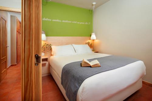 a bedroom with a bed with a book on it at PirineosNature Apartments in Plan
