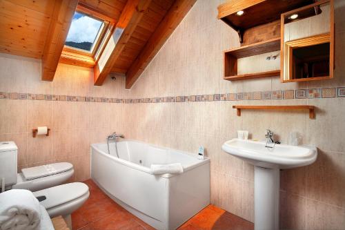 a bathroom with a tub and a sink and a toilet at PirineosNature Apartments in Plan