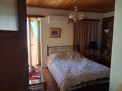 a bedroom with a bed and a window at πλατανα Αστρους Αρκαδίας χωριατικο σπίτι για φυση και ηρεμία in Rounaíika