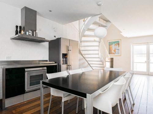 een keuken met een zwarte tafel en witte stoelen bij 6 person holiday home in Skagen in Skagen