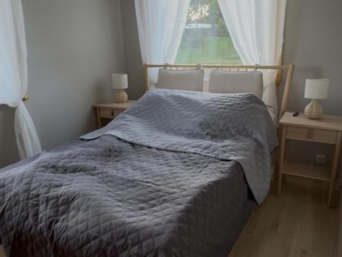 een bed in een slaapkamer met 2 stoelen en een raam bij Domek na Kaszubach u Doroty 