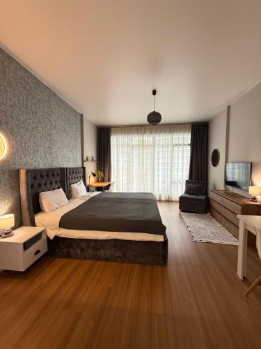 a bedroom with a large bed and a television at Вид на закат, море и бассейн in Batumi