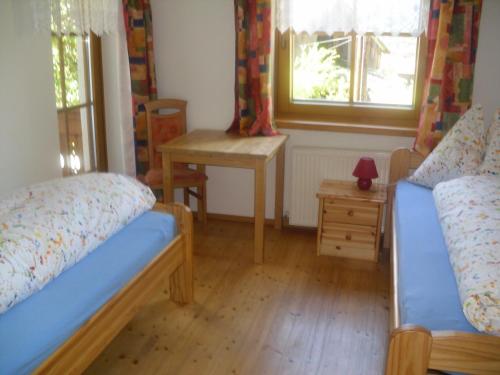a bedroom with two beds and a table and a window at Nagelehof in Ainet