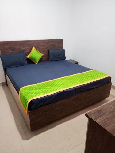 a large bed with a blue and green comforter at Rooms with WiFi, Parking - 3BHK Villa in Kodaikānāl