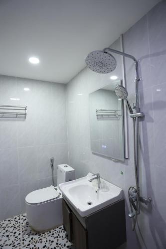 a bathroom with a sink and a toilet and a mirror at We House River View Hotel And Travel in Luang Prabang