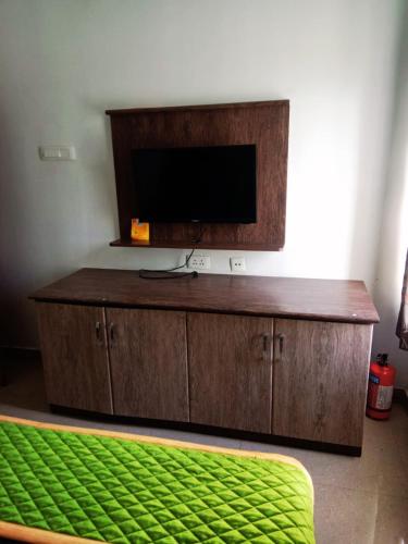 a wooden entertainment center with a flat screen tv at Rooms with WiFi, Parking - 3BHK Villa in Kodaikānāl