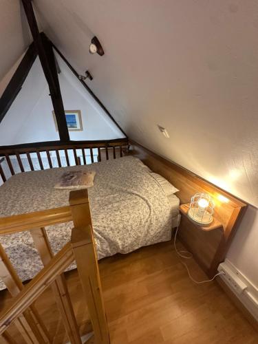 een kleine slaapkamer met een bed op zolder bij Manoir de la Vente de Rouville in Mesnil-Raoul