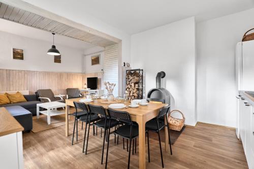 Una cocina y una sala de estar con mesa y sillas. en Chalupa U přátel, en Kovářská