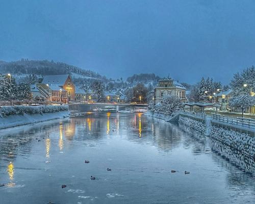 a town with a river in the snow at night at Apartmány Bašta & Wellness in Sušice