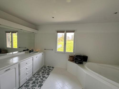 een witte badkamer met een bad en een wastafel bij Chambres d'hôtes , Guest house in Chainaz-les-Frasses