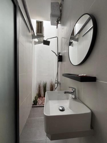 a bathroom with a sink and a mirror at Mai House Jogja in Piyungan