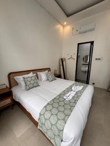 a bedroom with a large white bed with pillows at Mai House Jogja in Piyungan