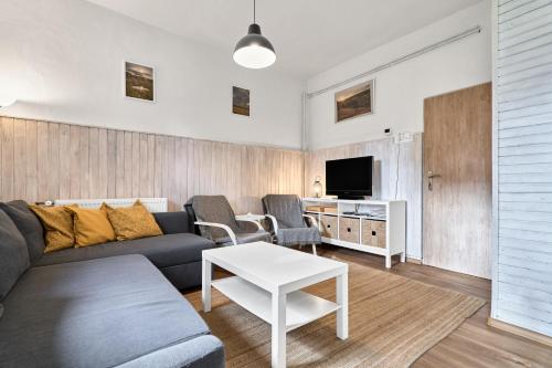 una sala de estar con un sofá y una mesa en Chalupa U přátel, en Kovářská