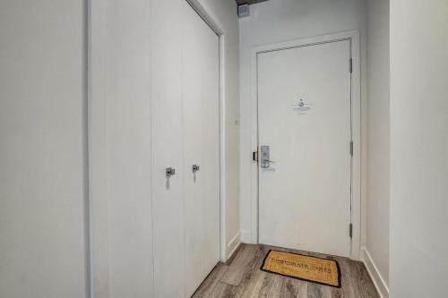 ein Flur mit einer weißen Tür und einem Holzboden in der Unterkunft Corporate Stays Le Shaughn 1 BR - Double Bed in Montreal