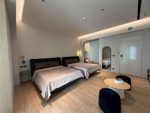 a bedroom with two beds and a table at Chuan Inn圈旅 站前館 in Tainan