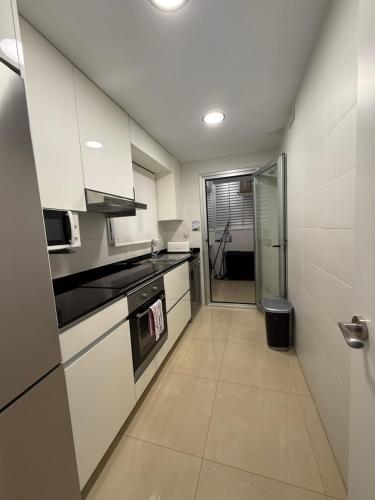 a kitchen with white cabinets and a glass door at Casa Miriam Family Lux in Oropesa del Mar