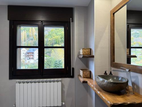 a bathroom with a bowl sink and a window at El Molino de Pochas in Bielsa