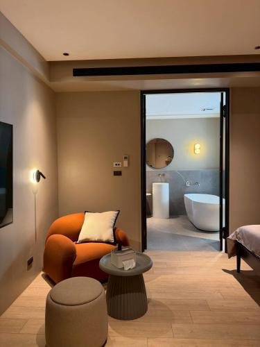 a living room with a chair and a bath tub at Chuan Inn圈旅 站前館 in Tainan