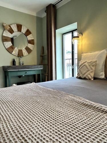 a bedroom with a bed with a mirror and a sink at Côté Nuit in Capestang