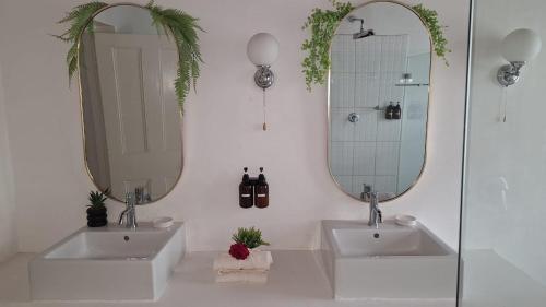 a bathroom with two sinks and a mirror at Karoo Sunset Villa in Richmond