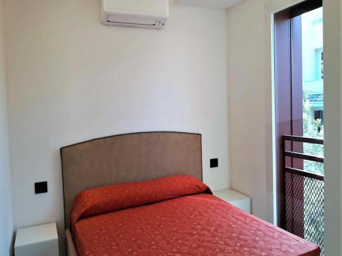 a bedroom with a bed with a red blanket at Modern villa close to the beach in Lignano Sabbiadoro