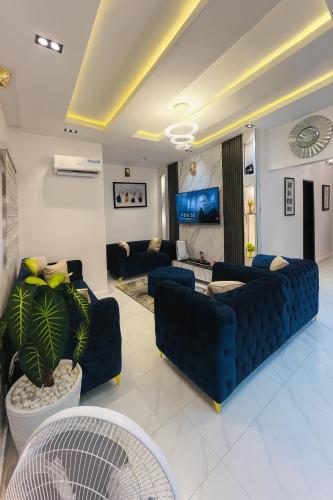 a living room with blue couches and a tv at 2 Bedroom Apartment - Flixx & Flixx Apartments in Ibadan