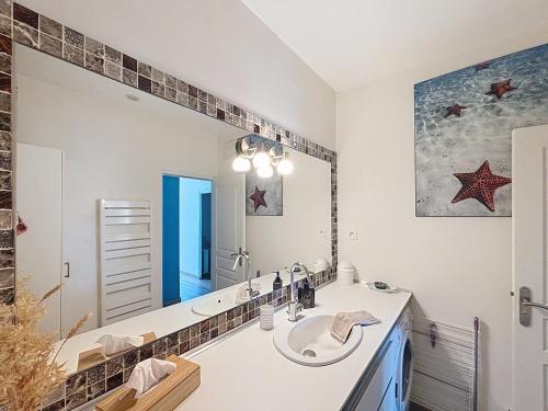a bathroom with a sink and a large mirror at CASA BLUE sur une jolie place proche du vieux port by LaConciergerie13 in La Ciotat