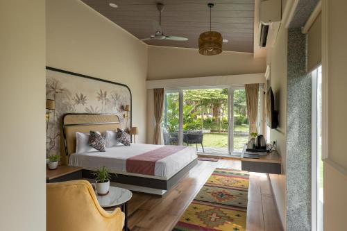 The Nest, Karjat في كارجات: غرفة نوم بها سرير ونافذة كبيرة