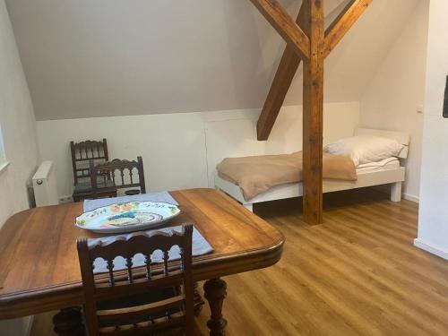 a dining room with a table and a bed at Gästewohnung Augsburg - Spickel in Augsburg