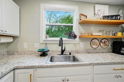 a kitchen with a sink and a window at Carriage House Retreat 1 in Milford