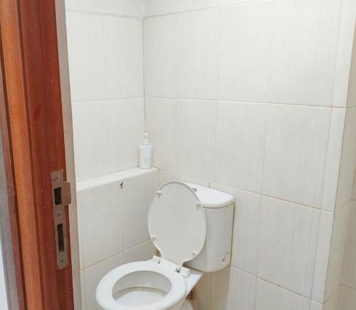a white bathroom with a toilet with the lid up at Bram Rooms Green Lake View Ciputat in Pondokcabe Hilir