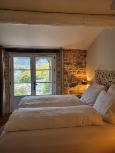 a bedroom with a large bed and a window at Mas Tulipe de Soie in Bevons