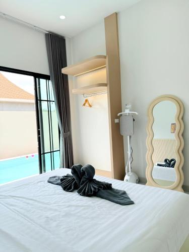 a bedroom with a bed with a black bow on it at Jaegun Pool VIlla Aonang in Ao Nam Mao