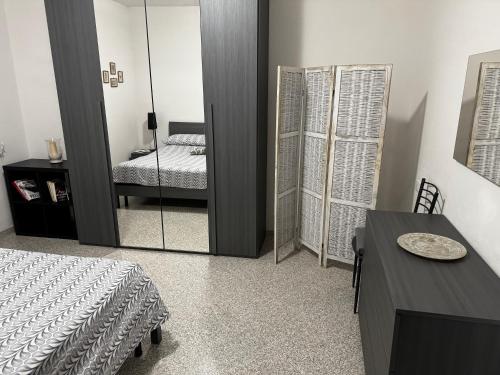 ein Schlafzimmer mit einem Spiegel, einem Bett und einem Tisch in der Unterkunft La Vecchia Chiassaia (mare/montagna) in La Pescaia